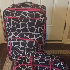 Giraffe print luggage with hot pink details.